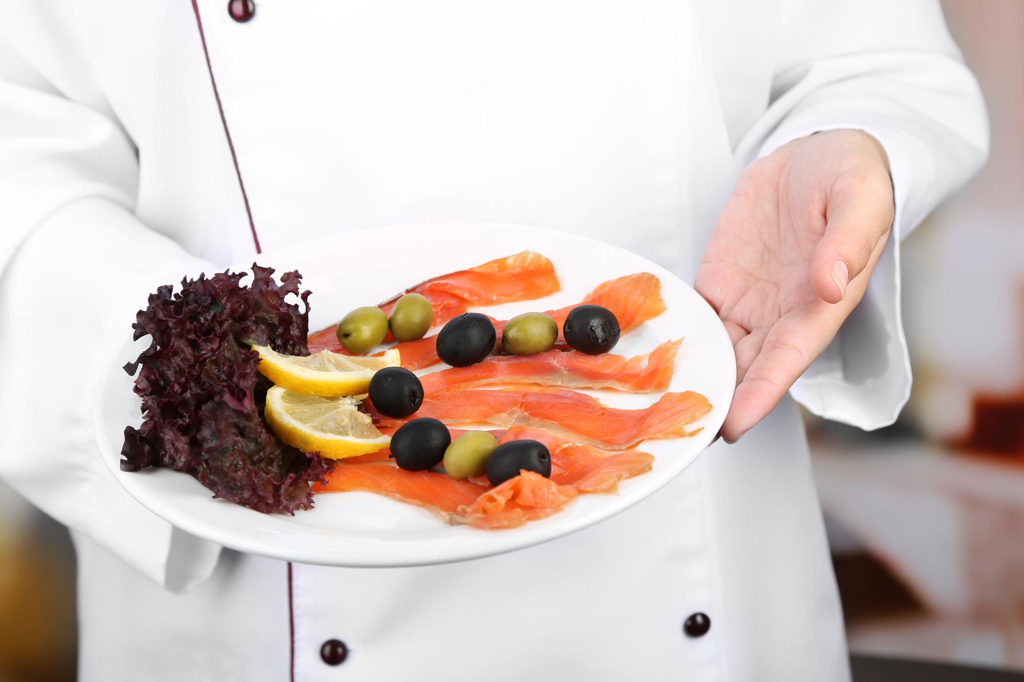 Chef hands arranging garnishes on plates